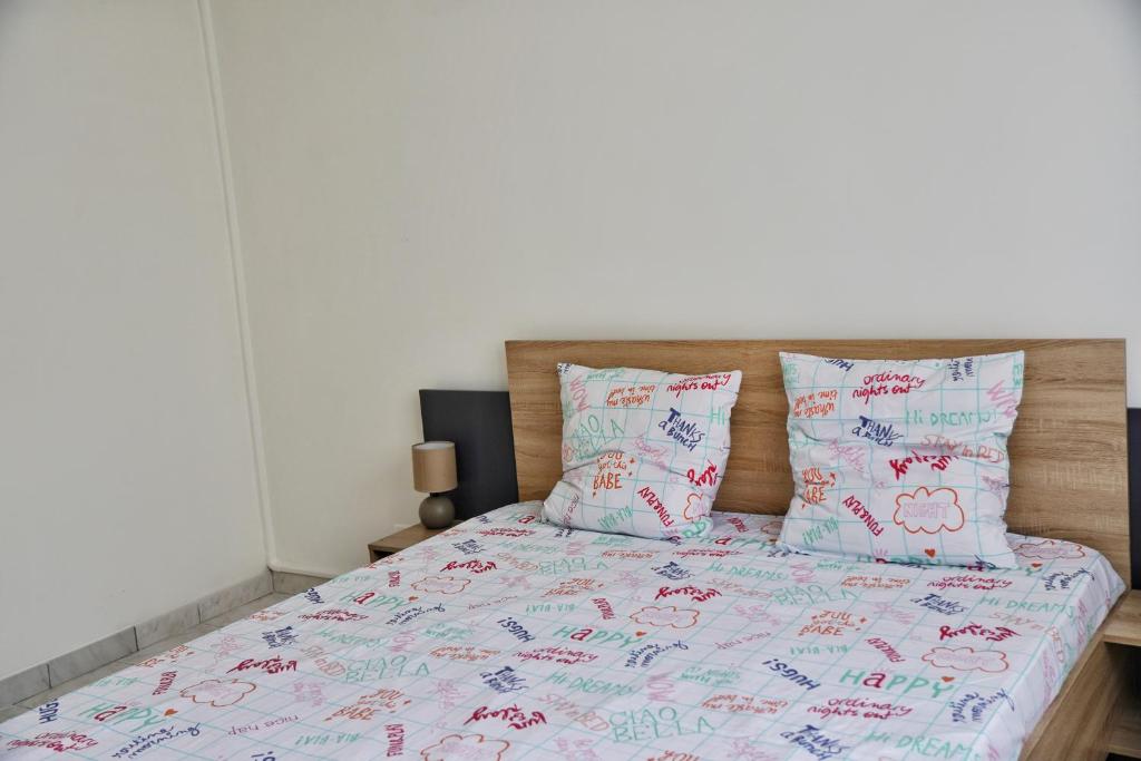 - une chambre avec un lit doté de draps et d'oreillers roses et bleus dans l'établissement Bas de Villa Vallon des Signes, à La Seyne-sur-Mer