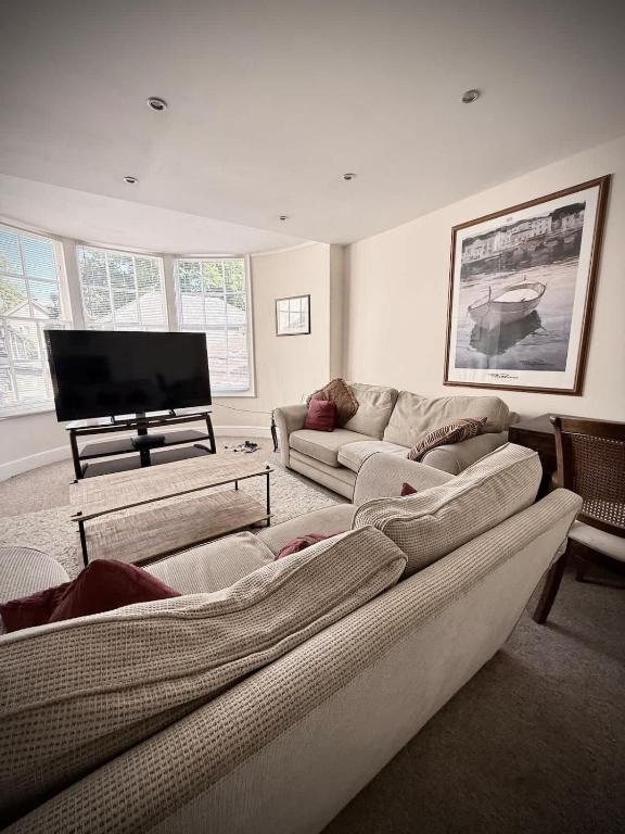 a living room with two couches and a flat screen tv at Churchgate Apartment in Bury Saint Edmunds