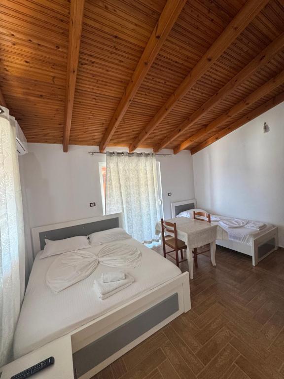 a bedroom with a bed and a table with a chair at CAUSHI Apartments Ksamil in Ksamil