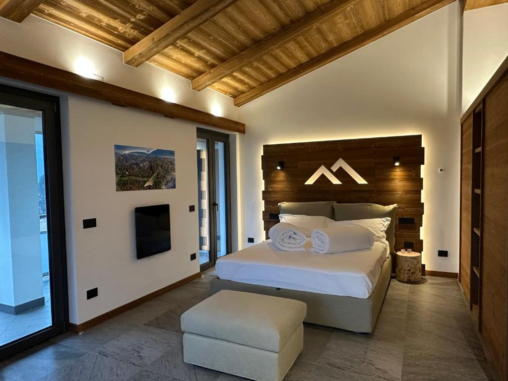 a bedroom with a large white bed and a chair at Valtellina SkyLine EST in Villa di Tirano