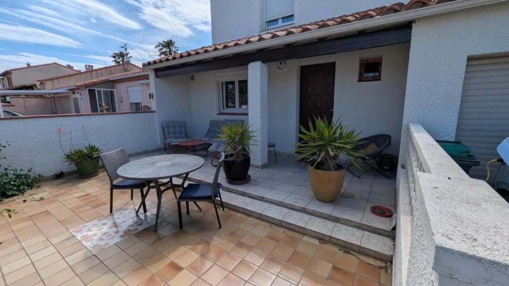 une terrasse avec une table et des chaises dans une maison dans l'établissement villa spacieuse avec terrasses et équipements prémium, à Bompas