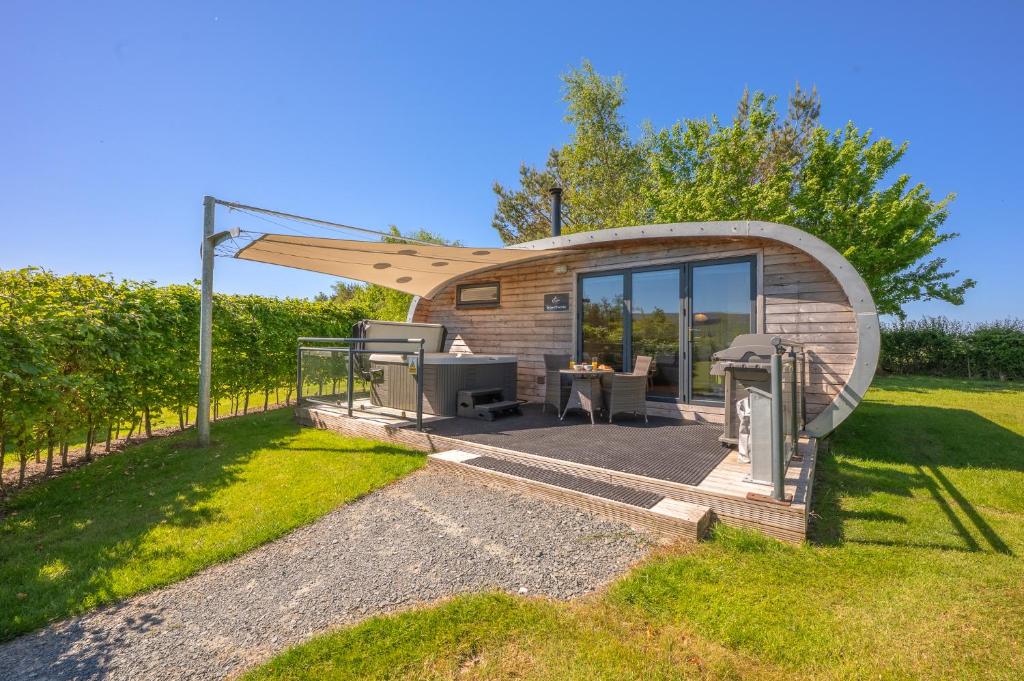 a small wooden cabin with a table in the grass at Brownthwaite Luxury Pod with Hot Tub at Fell View Park Kirkby Lonsdale in Casterton