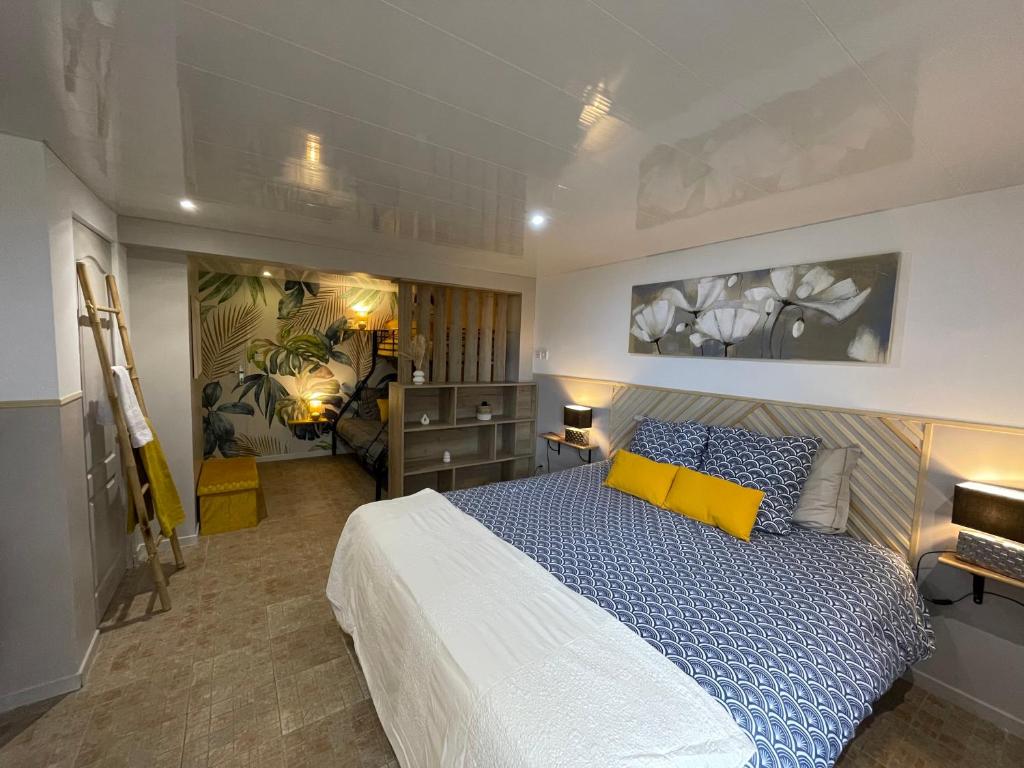 une chambre avec un lit avec des oreillers bleus et jaunes dans l'établissement Chambres et tables d hôtes du Boiziller, 