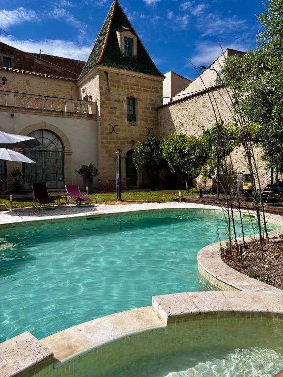 une piscine devant un immeuble dans l'établissement Les Galeries de Beaulac, à Pézenas