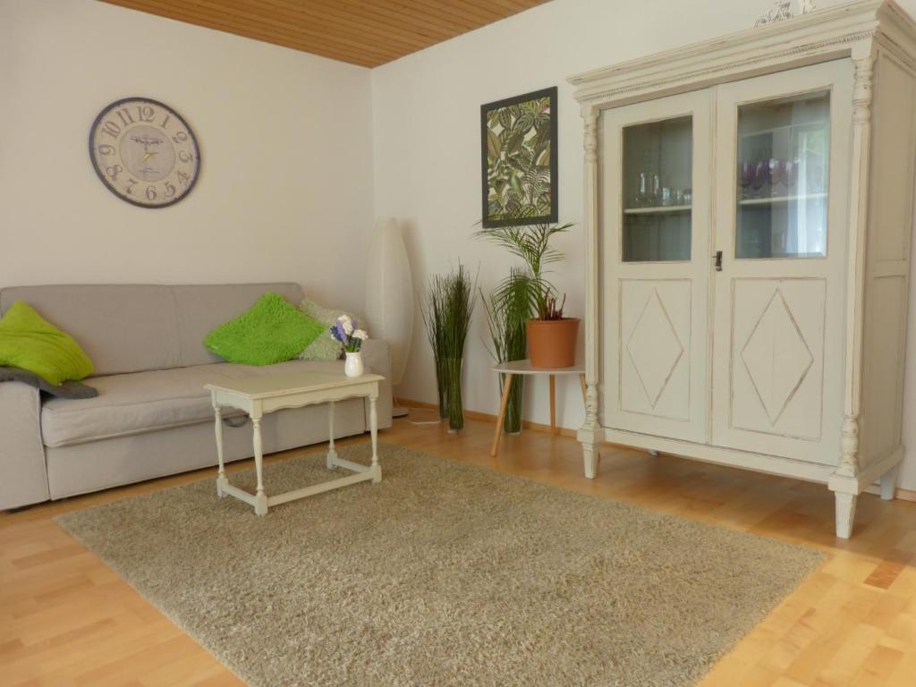 un salon avec un canapé et une horloge au mur dans l'établissement Ferienwohnung Ronja, à Großengstingen