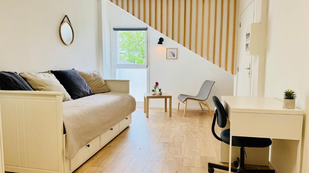 Un dormitorio con una cama, un escritorio y una mesa. en Studio L'Essentiel - Parking & Wifi, en Troyes