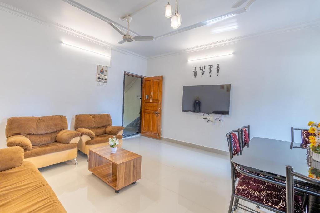 una sala de estar con un sofá y una mesa en 2BHK Apartment In Colva 1 km to the beach, en Colva