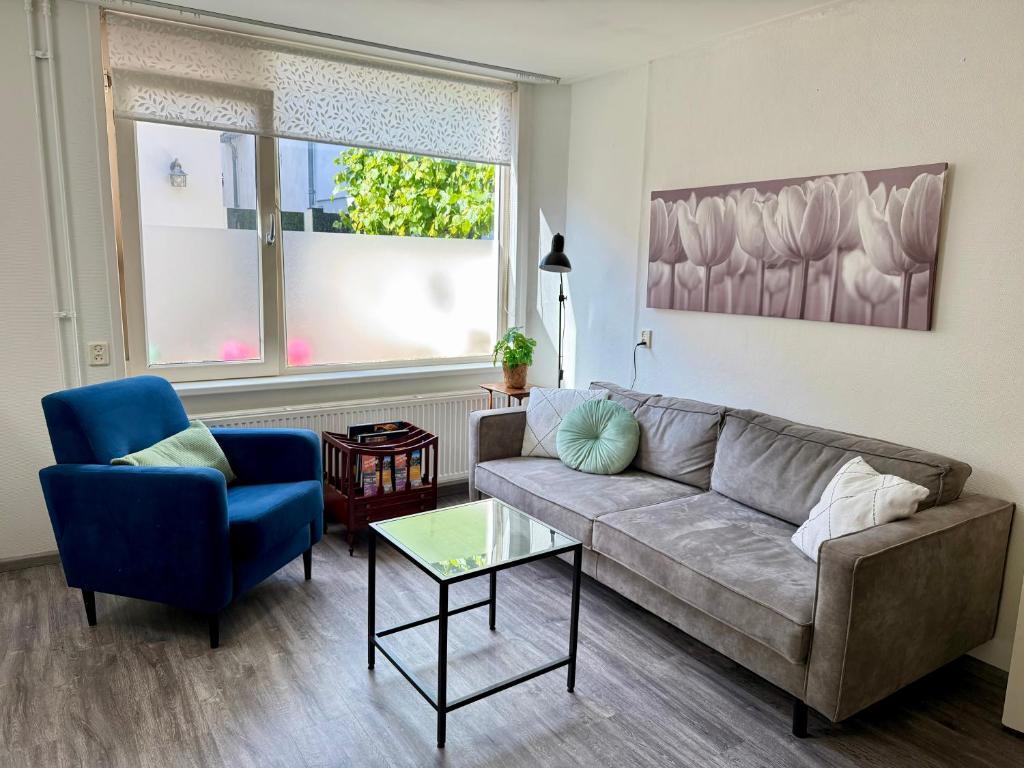 una sala de estar con un sofá y una silla en Noordwijk Sur-Mer, en Noordwijk aan Zee