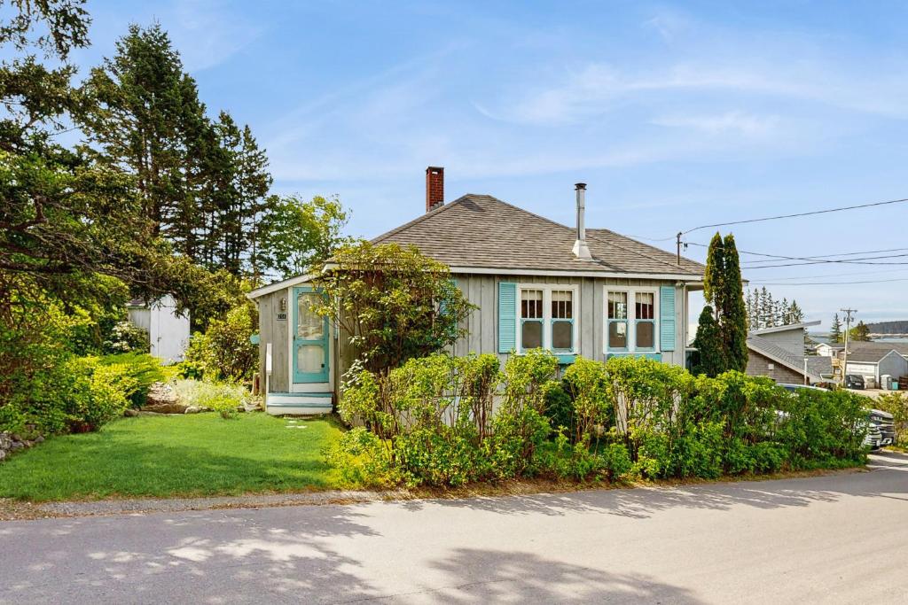 ein blaues Haus mit einem Zaun davor in der Unterkunft Blue Sky Cottage in South Thomaston