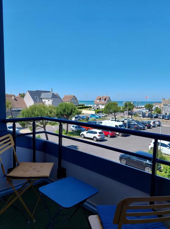 d'un balcon avec des chaises et une vue sur le parking. dans l'établissement Le Patio, à Courseulles-sur-Mer