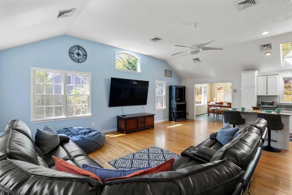 a living room with a couch and a flat screen tv at Short Walk to Swan Pond Hot Tub in Dennis