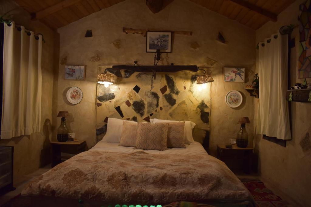 a bedroom with a bed and a stone wall at Le petit Olivier 