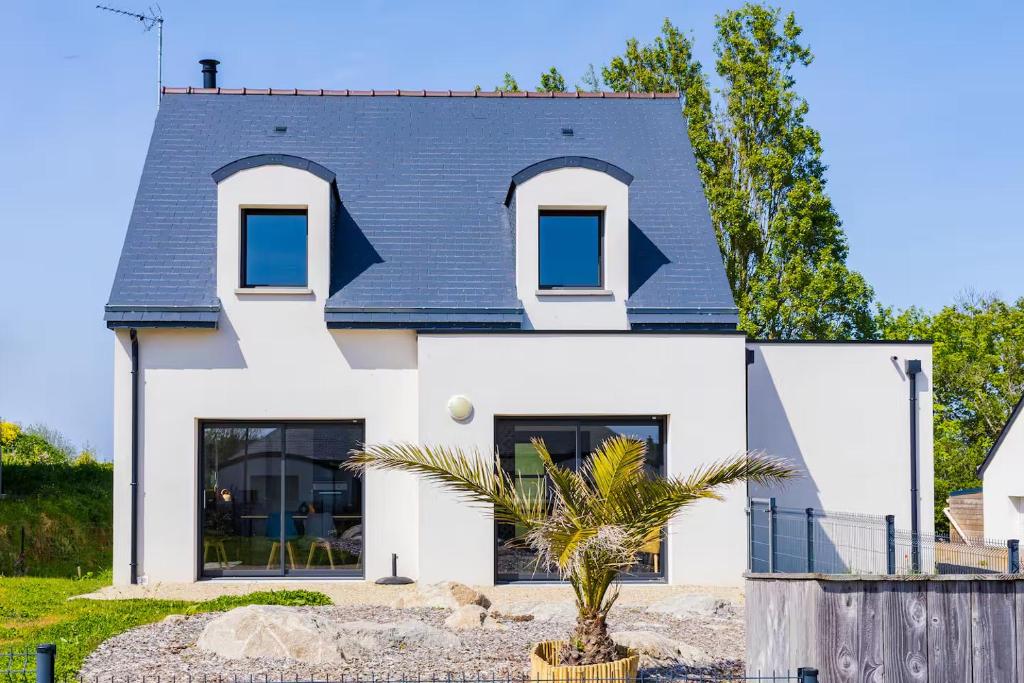 une maison blanche avec un toit bleu dans l'établissement Maison neuve à deux pas de la plage et du GR34, à Pleubian