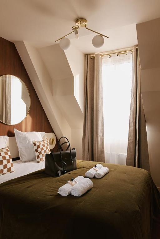 une chambre avec un lit avec deux serviettes dessus dans l'établissement Résidence Louvre, à Paris