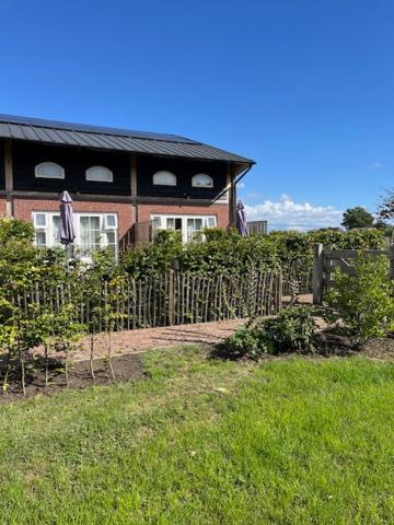 a house with a fence in front of it at De Citadel - De Boomgaard in Markelo