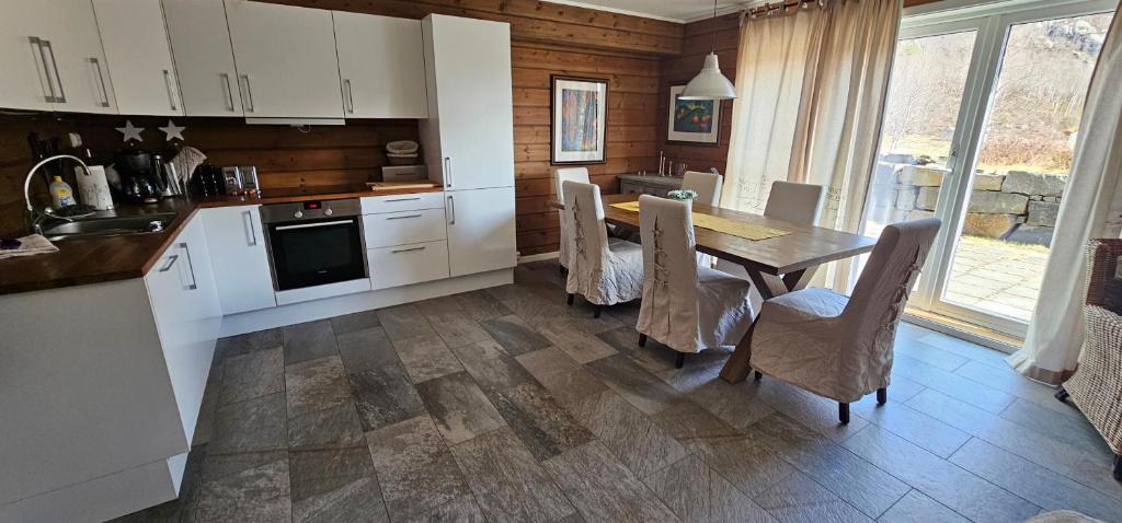 a kitchen with a table and chairs and a kitchen with white cabinets at Wonderful cabin in Sirdal in Haugen