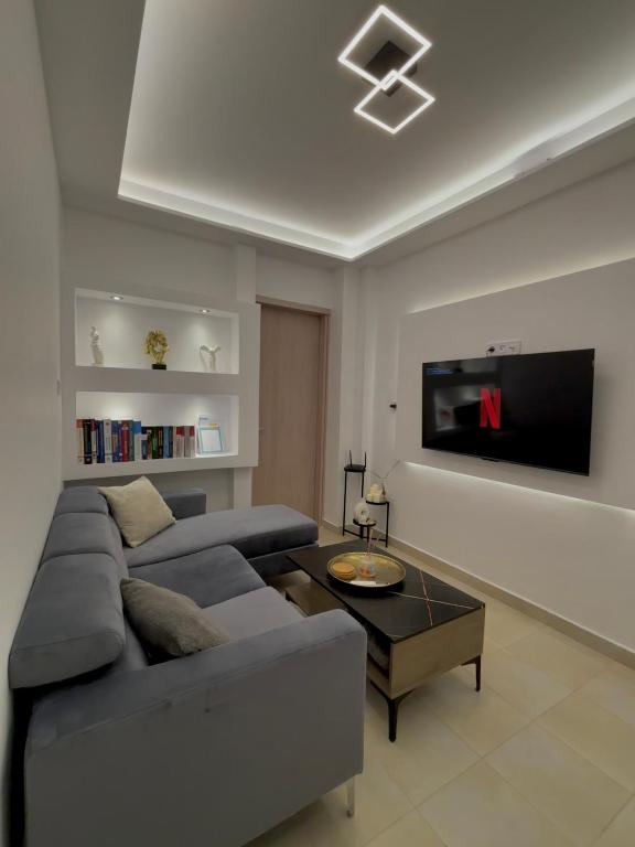 a living room with a couch and a tv at Bright & Stylish Apartment in the centre in Serres