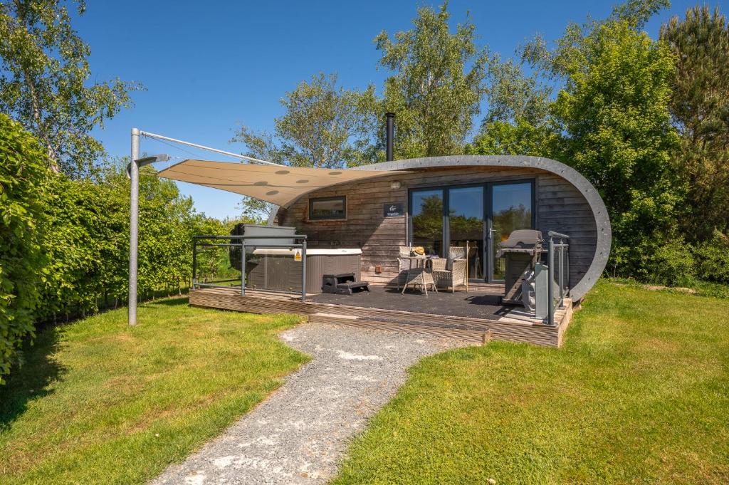 a circular building with a roof on a grass field at Kingsdale Luxury Pod with Hot Tub at Fell View Park Kirkby Lonsdale in Kirkby Lonsdale