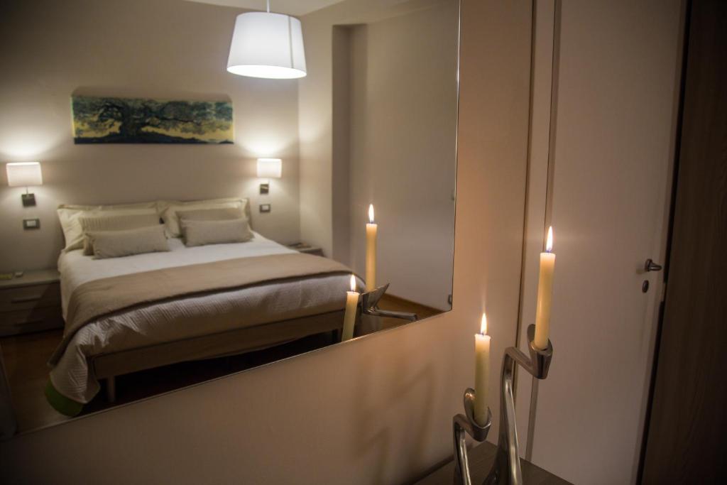 a bedroom with a mirror and a bed with two candles at Casa del Jazz Historical Center in Piazza Armerina