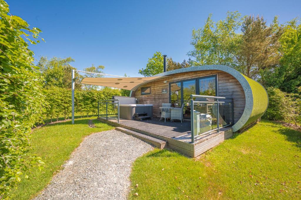 a circular house with a deck in the grass at Spring Wood Luxury Pod with Hot Tub at Fell View Park Kirkby Lonsdale in Casterton
