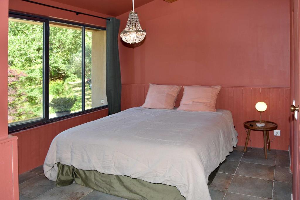 - une chambre avec un grand lit dans une pièce dotée de fenêtres dans l'établissement Les Restanques de la Baucoué - Dépendance, à Roquevaire