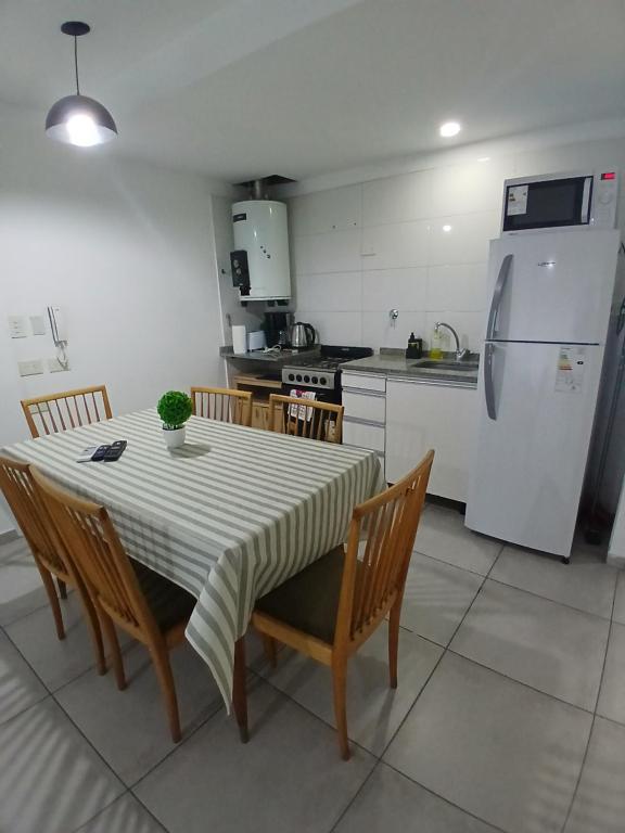 a kitchen with a table and chairs and a refrigerator at Apartamento LH Cómodo y moderno Cerca del aeropuerto Ezeiza ex fader in Luis Guillón