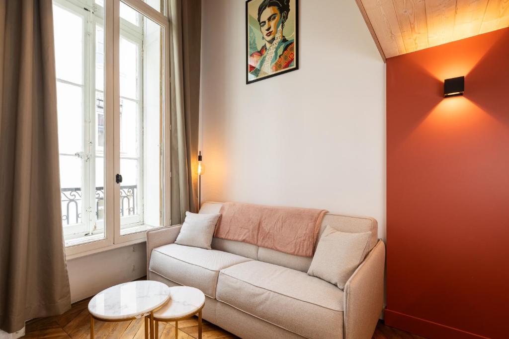 a living room with a couch and a window at SmartStay Traboule - Place Bellecour in Lyon
