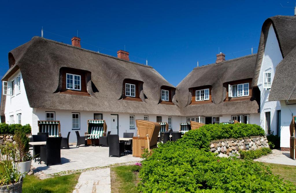 Une rangée de maisons avec des chaises devant elles dans l'établissement Strandvogtei Sylt, à Rantum