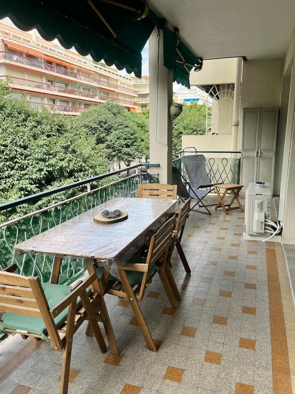 une table et des chaises en bois sur un balcon dans l'établissement Antibes carré d'or 3P Albert 1er Le Gazan, à Antibes