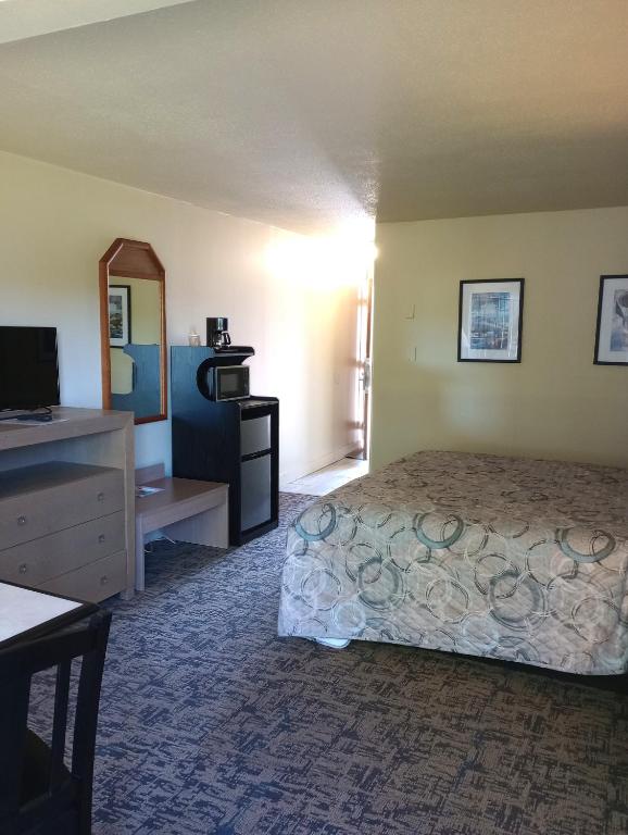a hotel room with a bed and a mirror at Cocusa Motel in Burlington