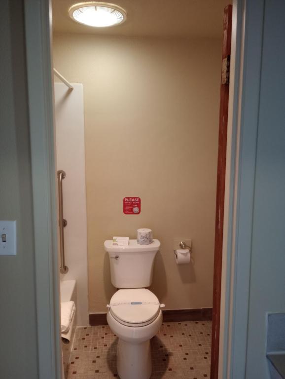 a bathroom with a white toilet in a room at Cocusa Motel in Burlington