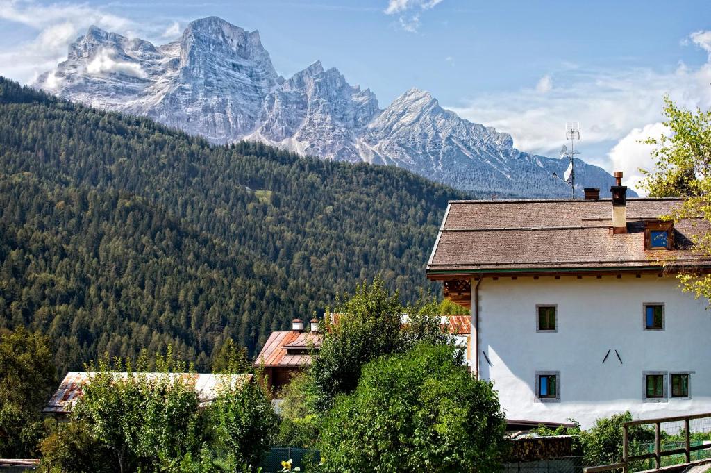 a house in front of a mountain range with trees at Alla Regia in Vodo Cadore