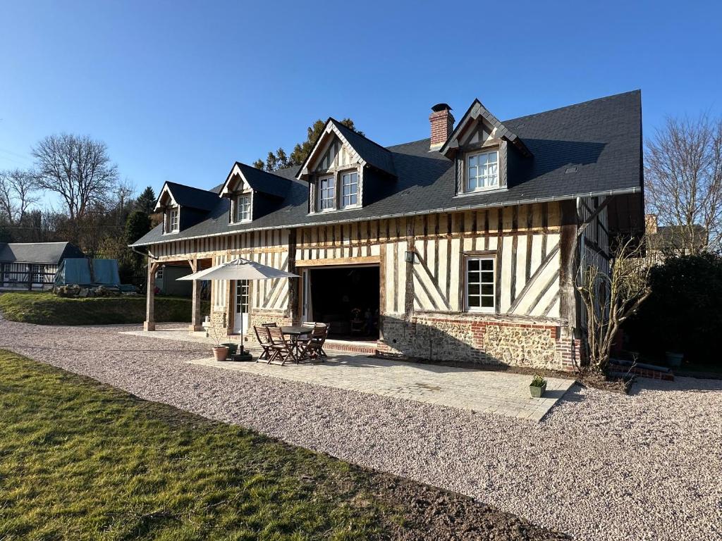 une maison avec un toit noir et une terrasse dans l'établissement La Charretrie, à Pierrefitte-en-Auge