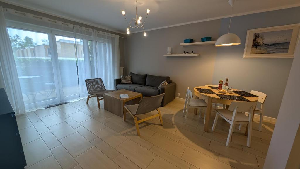 una sala de estar con una mesa y un sofá en Apartamenty Morze Wygody, en Międzywodzie