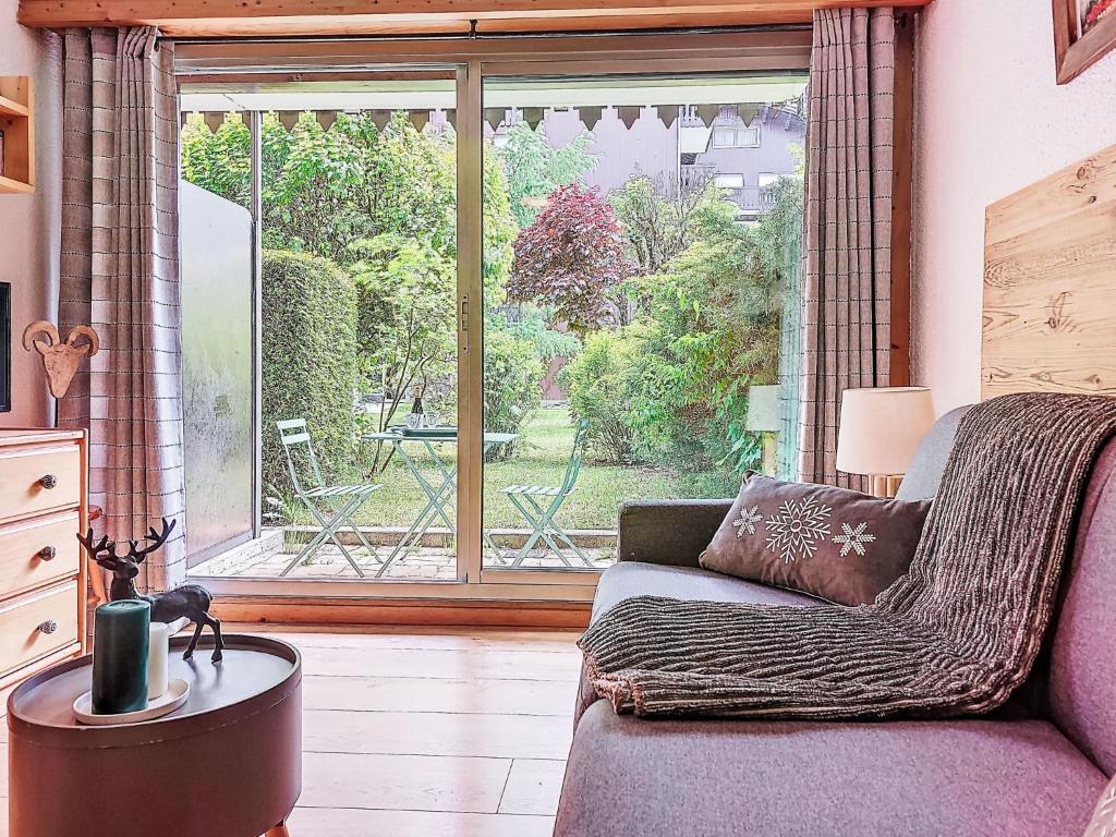 un salon avec un canapé et une grande fenêtre dans l'établissement Studio Clos du Savoy-22 by Interhome, à Chamonix-Mont-Blanc