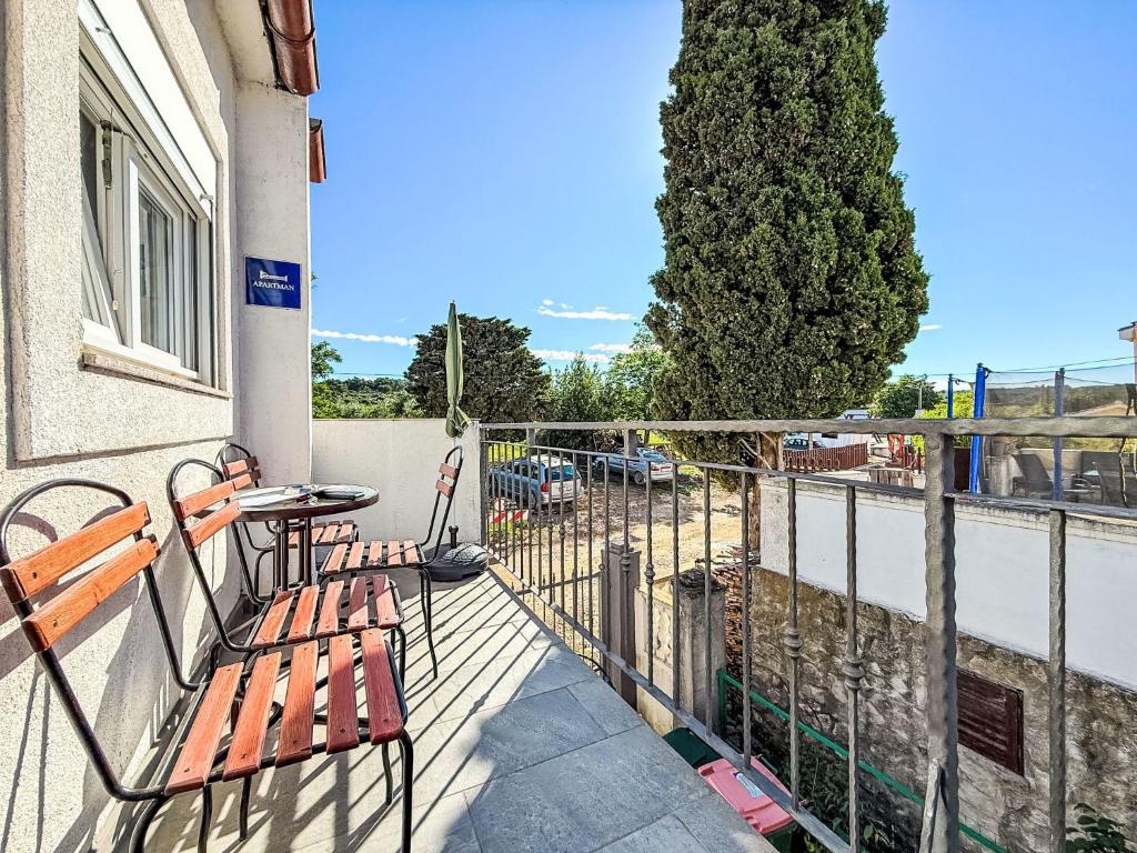 ein Balkon mit Tisch und Stühlen und einem Baum in der Unterkunft Apartment Lucia by Interhome in Zadar