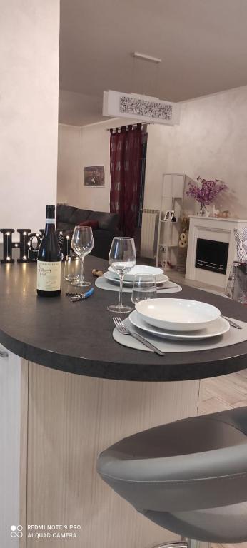 a kitchen with a table with plates and wine glasses at Ľ angolo della quaquara in Genola