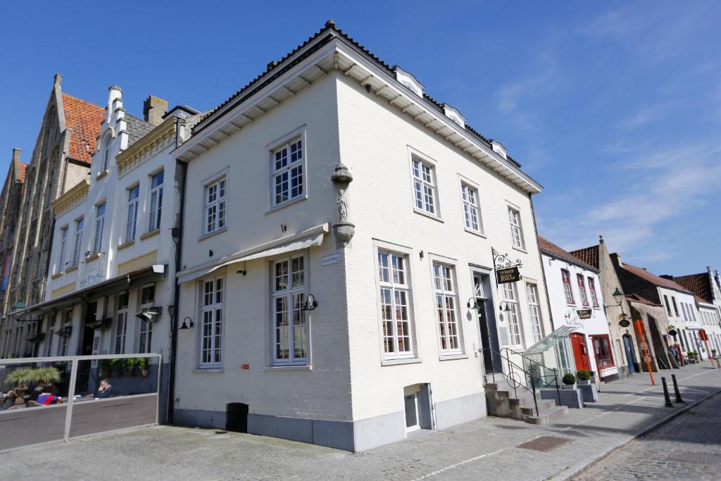 un bâtiment blanc sur le côté d'une rue dans l'établissement De Gouden Kop 3 Centrum Damme, à Damme