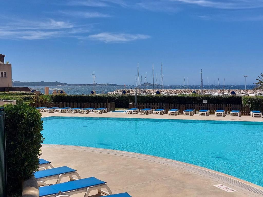 une grande piscine avec des chaises longues et l'océan dans l'établissement Apartment Les Rivages de Coudoulière-29 by Interhome, à Six-Fours-les-Plages