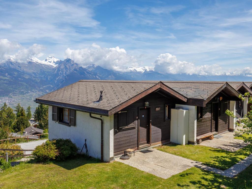 a house on a hill with mountains in the background at Chalet Tsamandon 22 by Interhome in Nendaz