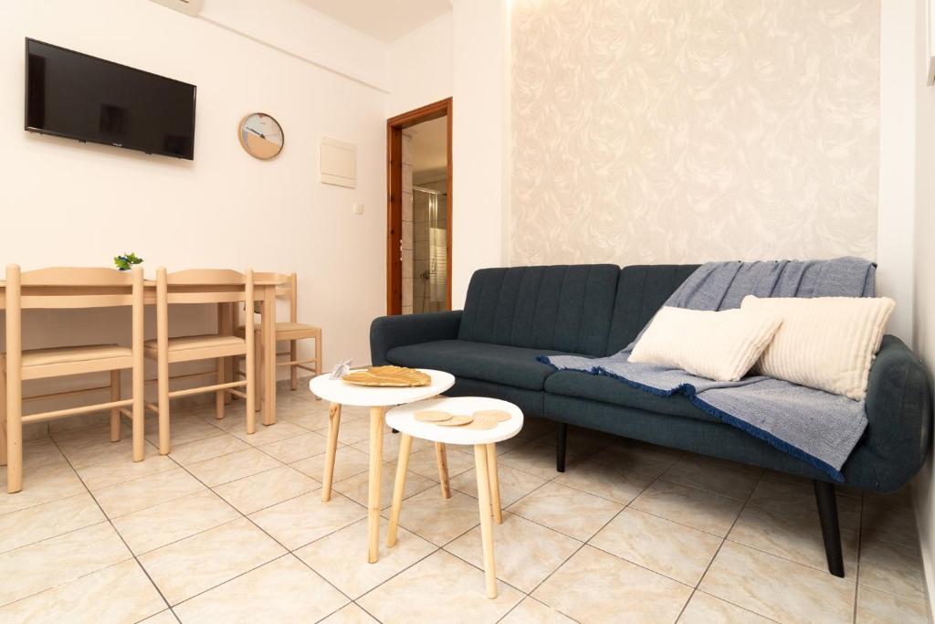 a living room with a blue couch and a table at Dream Apartments 3 in Palaiochóra