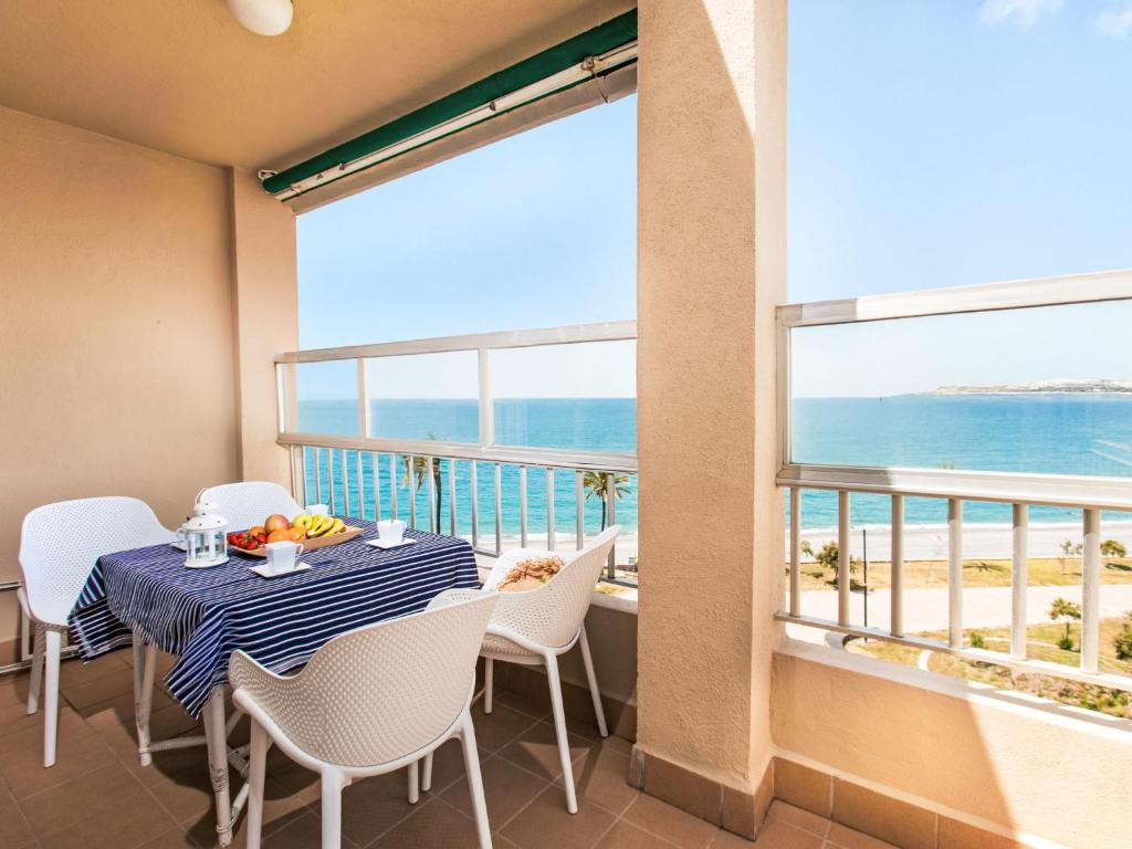 a dining room with a table and chairs and a view of the ocean at Apartment Marina by Interhome in Salobreña
