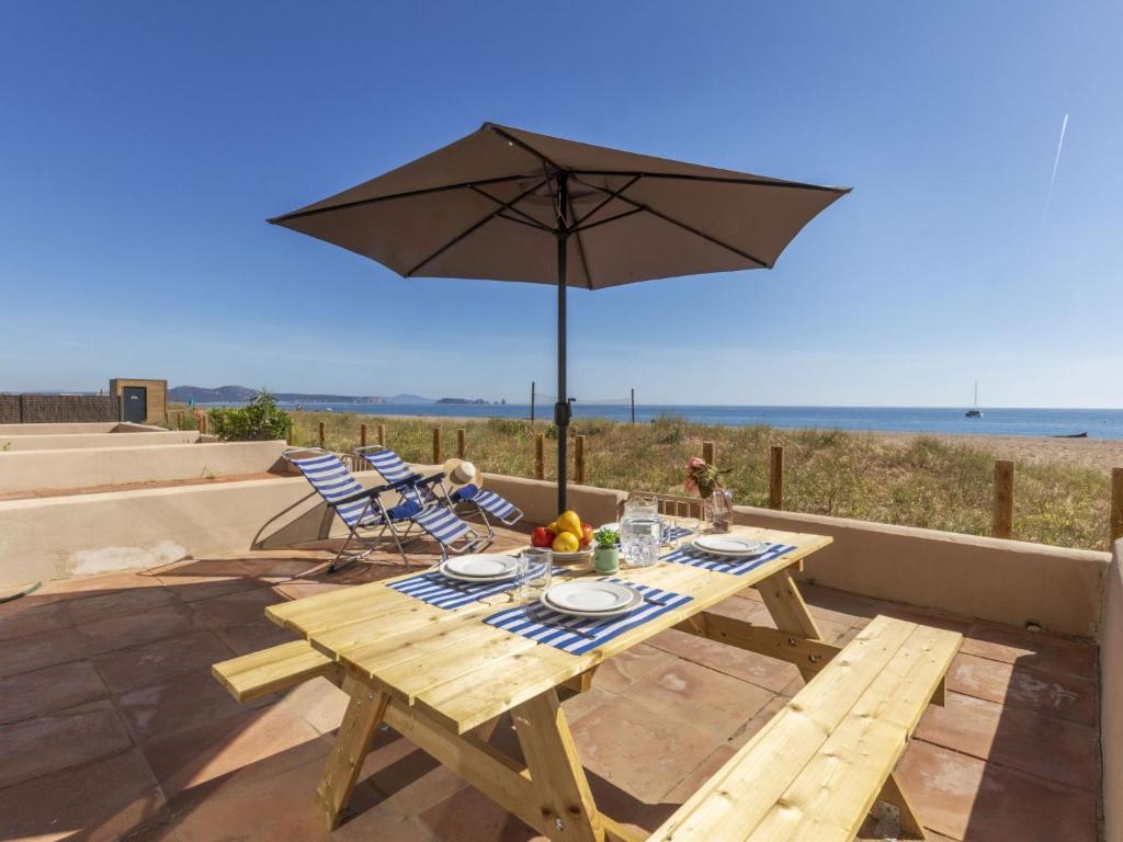 a picnic table with an umbrella on the beach at Apartment Paradise beach by Interhome in Begur
