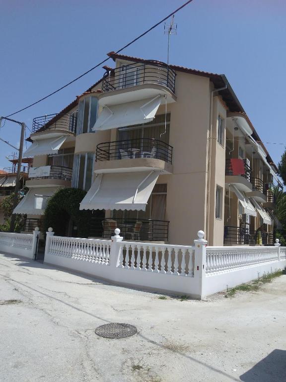 a white fence in front of a building at Villa Popi in Limenas