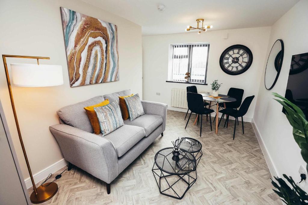 ein Wohnzimmer mit Sofa und Tisch in der Unterkunft Hen & Chickens Luxury Apartments, Free Parking, By DerBnB in Derby