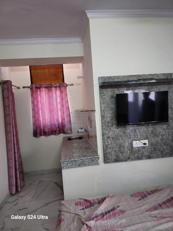 a room with a television and a bed in a room at Shree Sai Stay in Gurgaon