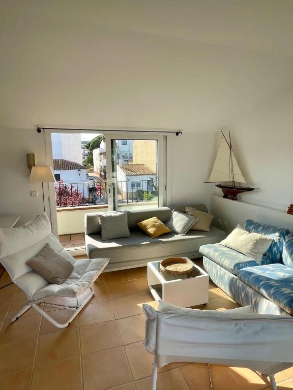 a living room with a couch and a chair at Confort al cor de Calella in Palafrugell