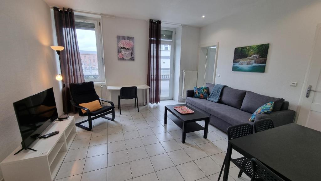 un salon avec un canapé et une télévision dans l'établissement Mulhouse gare, au bout du quai, à Mulhouse