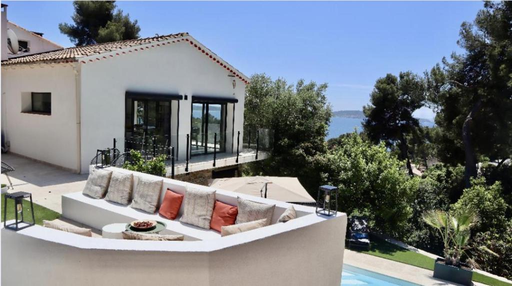 un canapé blanc assis sur le côté d'une maison dans l'établissement Villa Kalliopé - Vue mer, à Hyères