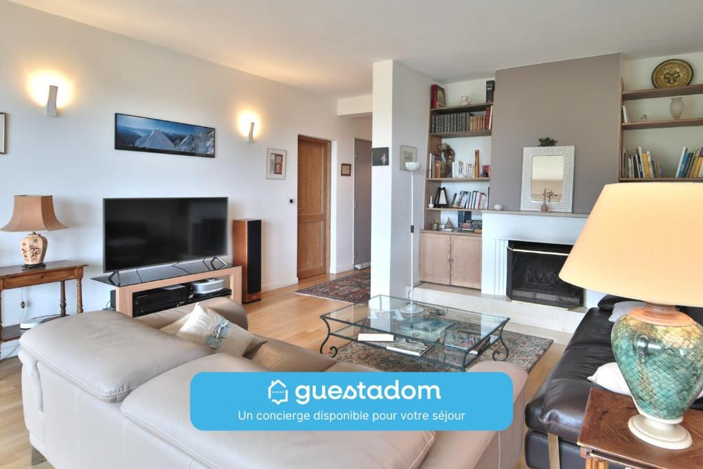 un salon avec un canapé et une cheminée dans l'établissement Havre familial standing Jardins Vue, à Marly-le-Roi